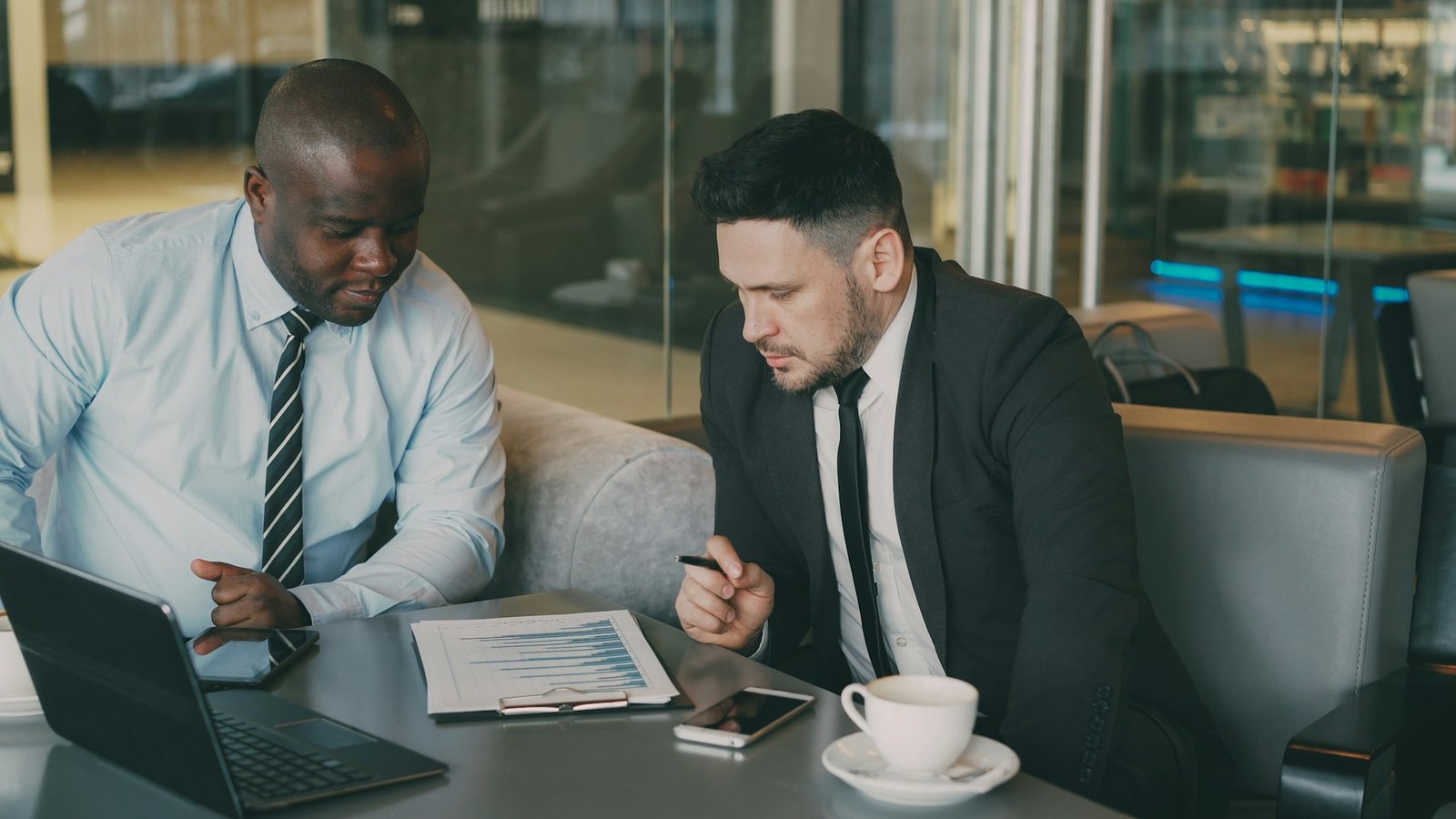 Two professionals reviewing proposal documents at a table